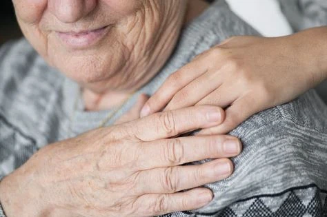 A reassuring hand resting on a patient's shoulder
